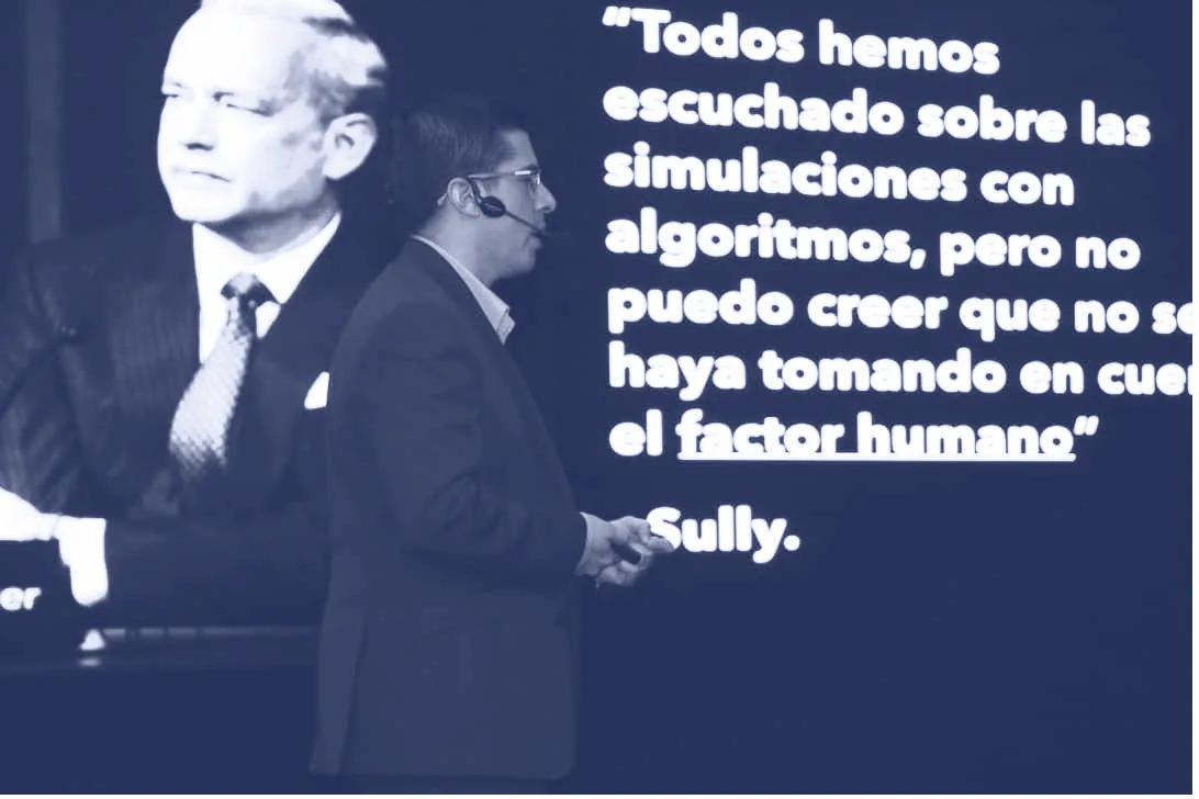 Alex Servin en la Universidad Rafael Landívar, con la cita del factor humano en pantalla
