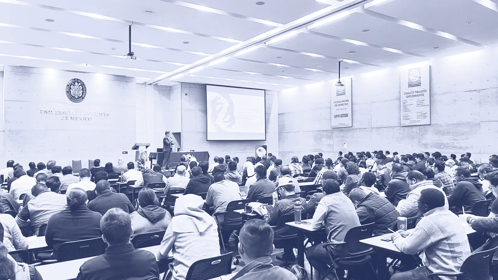 Aula magna llena en la Universidad Pontificia de México durante una conferencia de Alex Servin